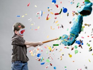 credit: Getty Images Boy hitting pinata, explosion of candy